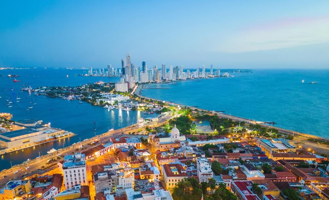 Cathedral tower rising above Cartagena's colonial rooftops at dusk, Colombia