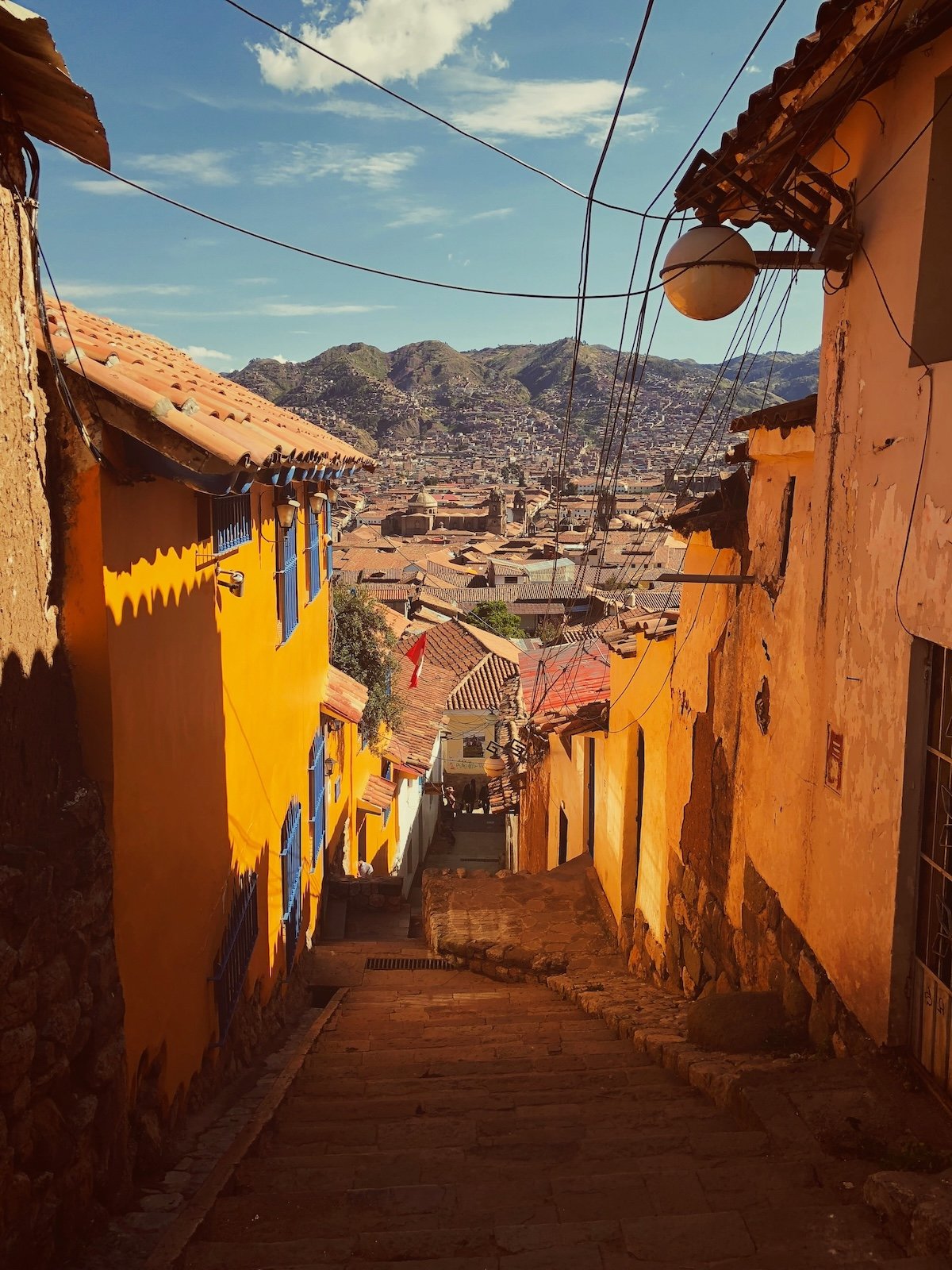 Golden-toned steep cobblestone street in Cusco's historic center, Peru