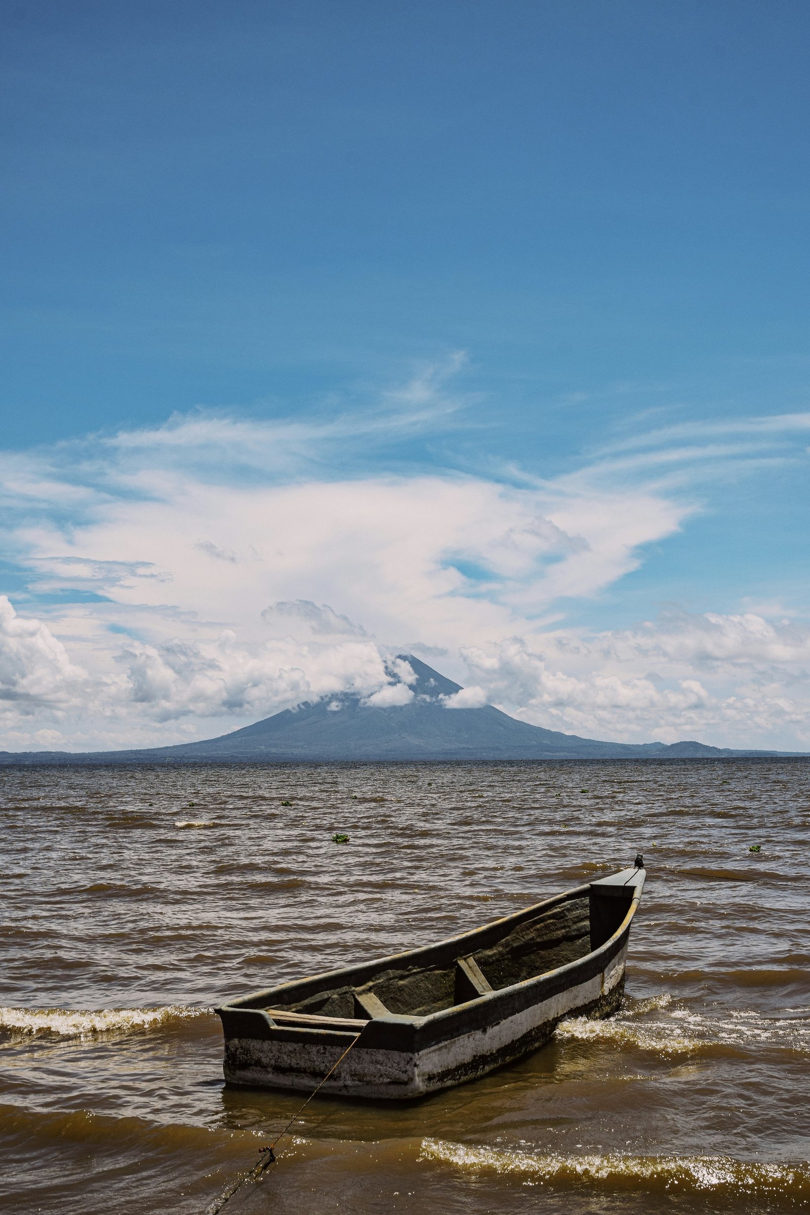 Wooden fishing boat moored on Lake Nicaragua with Concepción volcano on Ometepe Island beyond