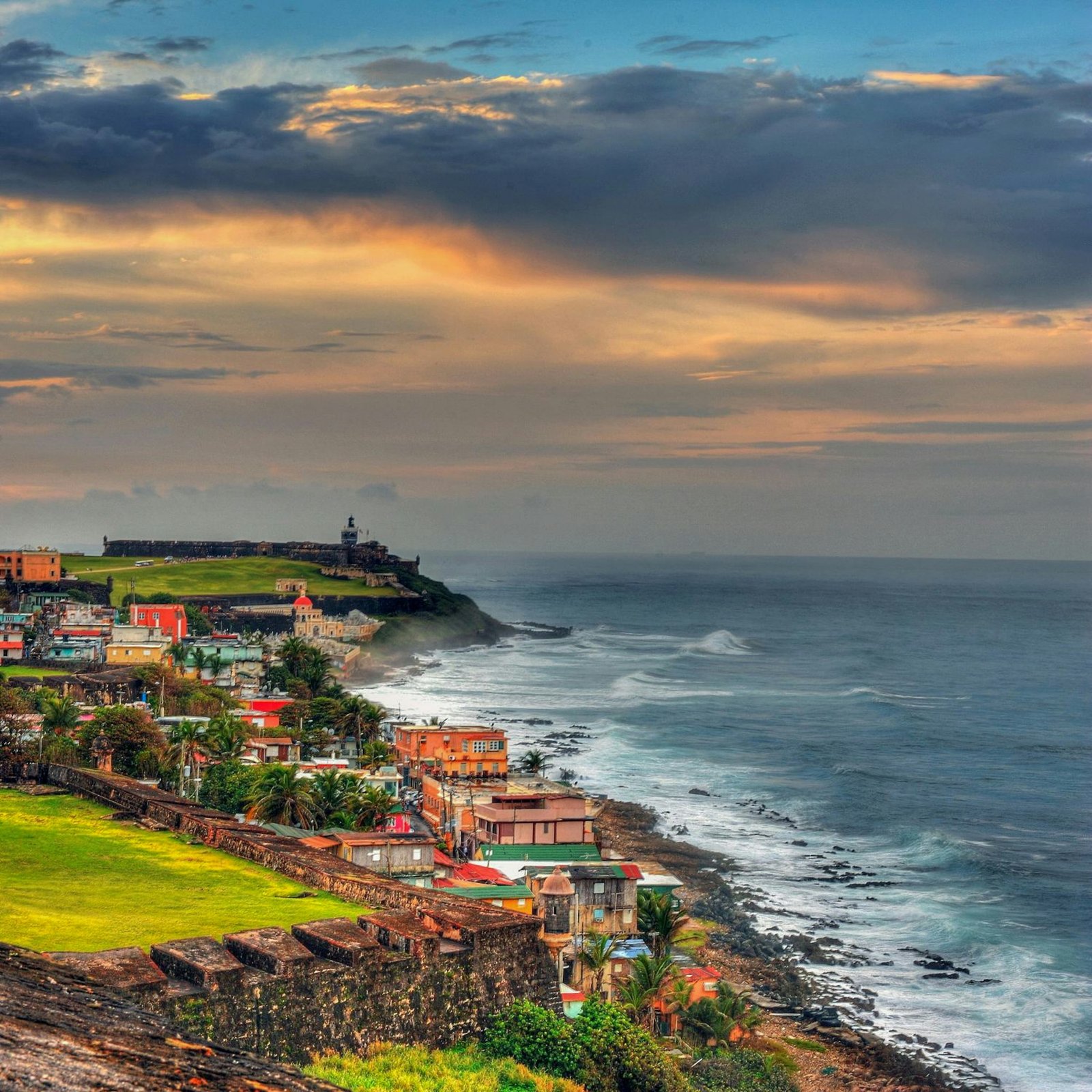 Sunset view over a Puerto Rico bay with palm trees and white hillside buildings